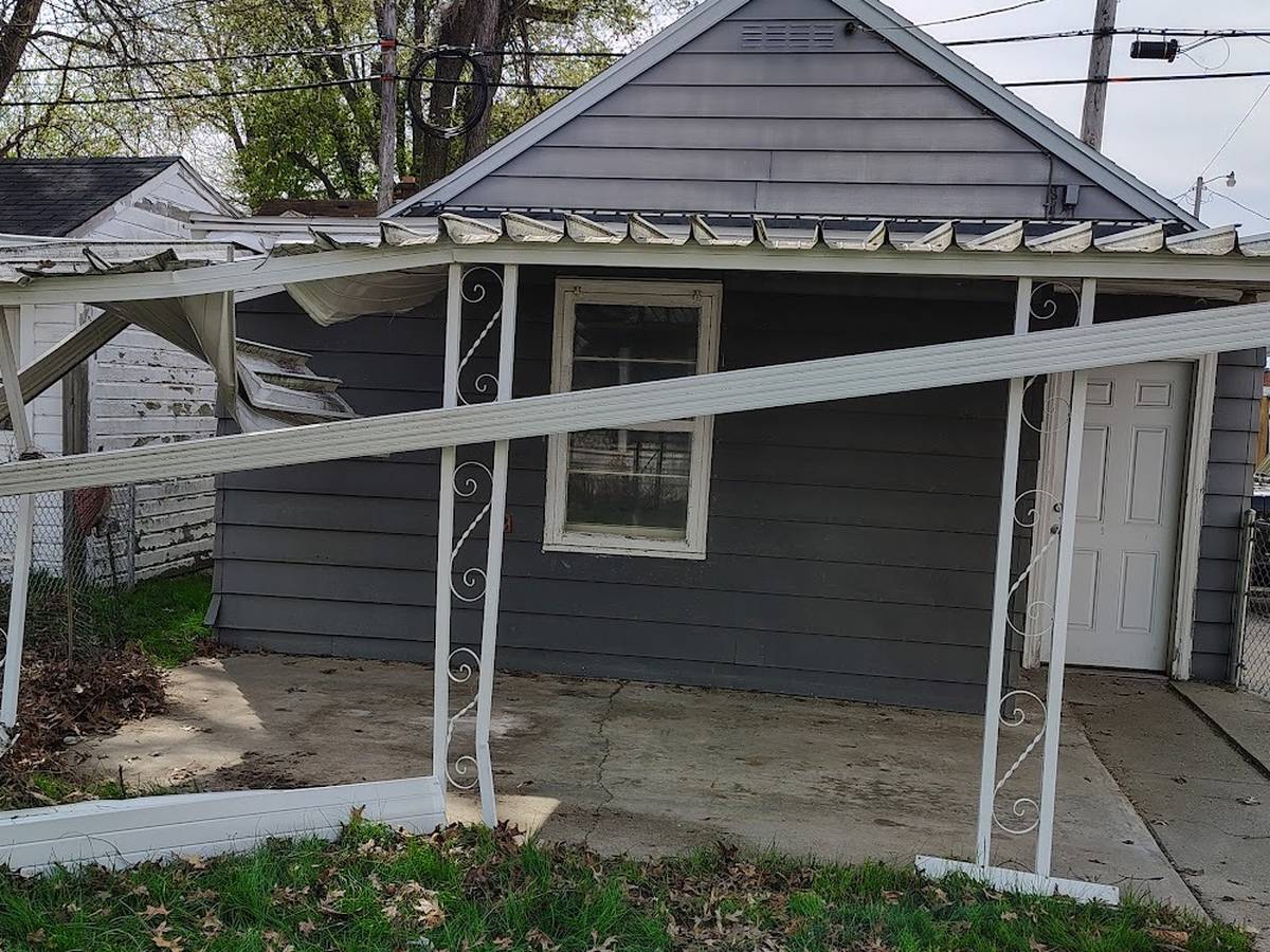 The same porch awning with the tree gone and the ground clear.